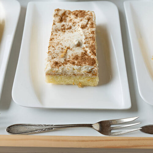 A simple frosted kefir sheet cake, topped with a smooth layer of white frosting and sliced into squares.