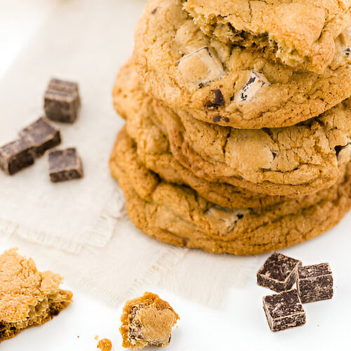 A tall stack of cookies and cream cookies with some leaning against the stack.