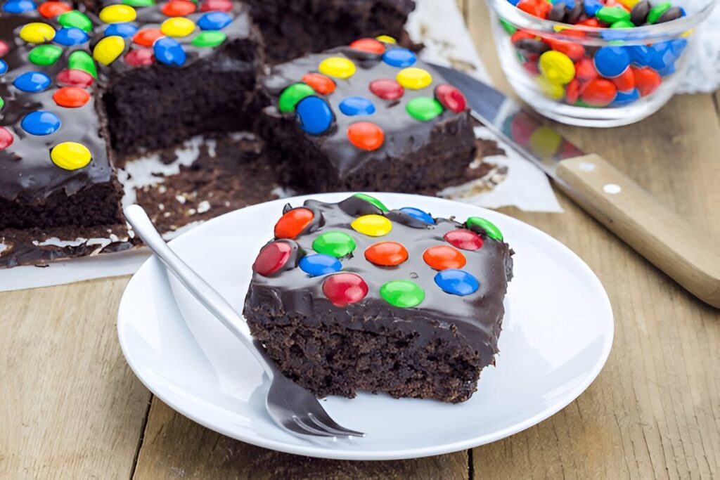 A serving of cosmic brownies with a fork on the side, showcasing the rich chocolate texture and colorful sprinkles.