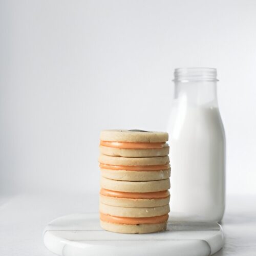 A stack of wafer cookies piled neatly on a wooden board, showcasing their golden, crispy texture.